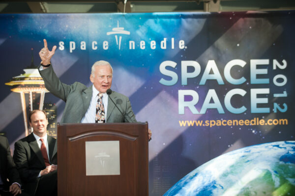 Buzz Aldrin speaking at a lectern at Space Needle's "Space Race 2012".